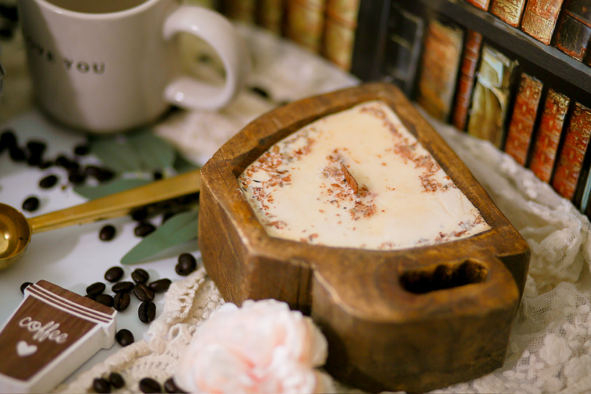 •	“Coffee mug-shaped wooden dough bowl candle by Abandoned Cakes, topped with dried botanicals”