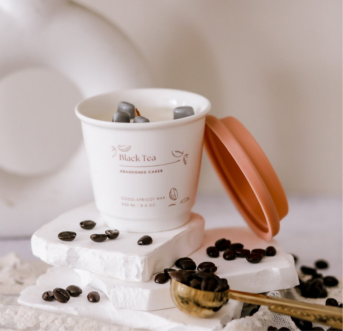 •	“Black Tea Candle by Abandoned Cakes in ceramic to-go cup with clean floral citrus scent”
	•	“Botanical tea-scented candle in café-style reusable cup with wood and musk base notes”